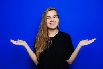 Happy beautiful woman without makeup in a black t-shirt showing different emotions on a blue background. Natural female beauty without cosmetics, naturalness. The concept of beauty