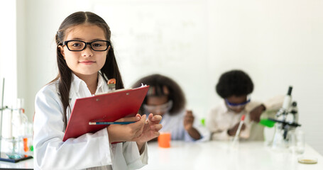 Group of teenage student learn science with teacher and study doing a chemical science experiment and holding test tube in hand in the experiment laboratory class on table at school.Education