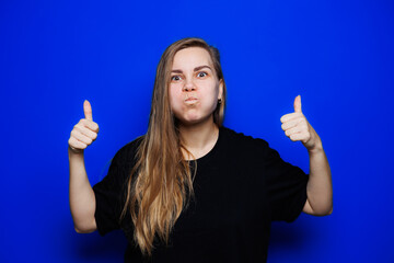 Happy beautiful woman without makeup in a black t-shirt showing different emotions on a blue background. Natural female beauty without cosmetics, naturalness. The concept of beauty