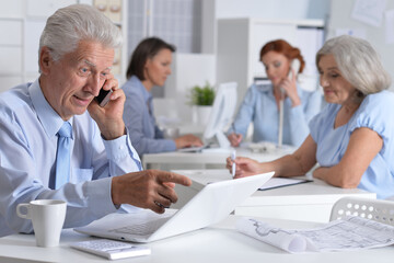 Fototapeta premium Business man talking on smartphone in light office