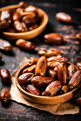 Delicious dates on a wooden plate. 