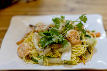 Stir-fried yellow noodles with prawns and fresh vegetables