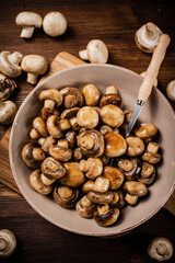 Fried mushrooms in a bowl on a cutting board. 