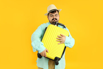 Concept of travel, young fat man on yellow background