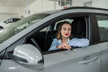 pretty smile young woman client inside at new modern auto and holding key, purcase concept