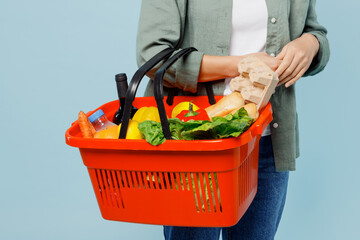 Cropped close up young woman wears casual clothes hold red basket with food products for preparing...