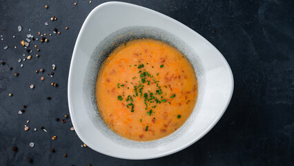 Hot red lentil soup with carrots, tomatoes and herbs.