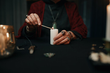 Closeup gypsy fortune teller lights candle for divination session