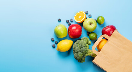 Shopping paper bag full of healthy food on blue