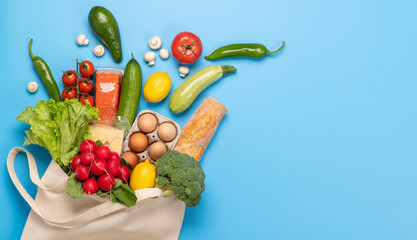 Shopping bag full of healthy food on blue