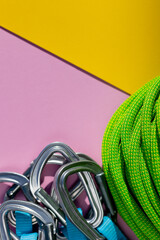 green rope and climbing and mountaineering equipment lies on a colored background. background image...
