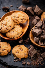 Cookies with pieces of milk chocolate on a stone board. 