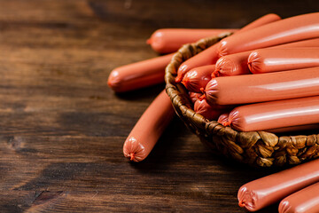Delicious boiled sausages in a basket on the table. 