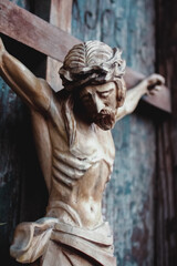 Fototapeta na wymiar Jesus Christ crucified. Closeup an ancient wooden statue. Vertical image.