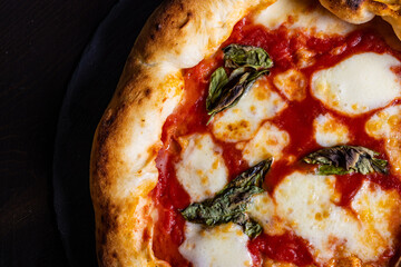 Pizza Margherita napoletana gourmet con sugo di pomodoro, mozzarella e basilico fresco servita in una pizzeria
