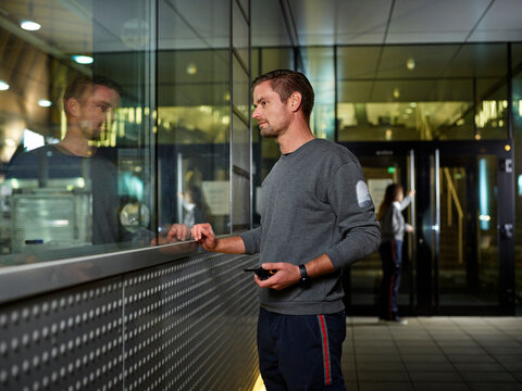Watchman standing at building reception holding walkie talkie