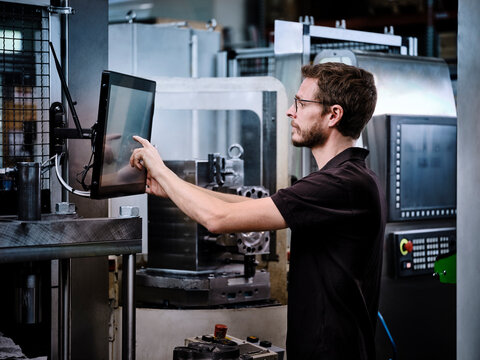 Technician operating machine in modern factory