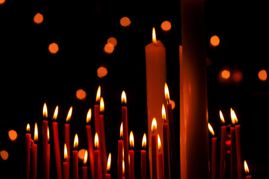 Candles burning against dark background