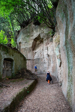 Senior man and woman walking on narrow road by rock