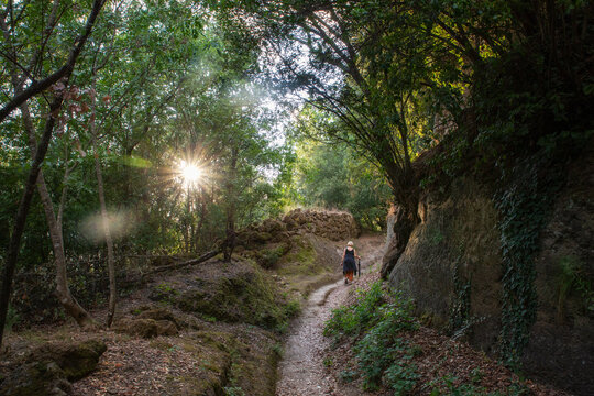 Active senior woman walking amidst rocks on sunny day