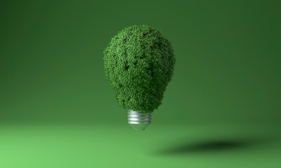 Light bulb covered with green plants against colored background