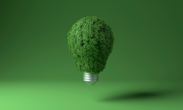 Light bulb covered with green plants against colored background