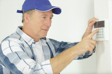 handsome senior electrician repairing intercom