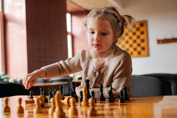 Cute girl playing chess at club house