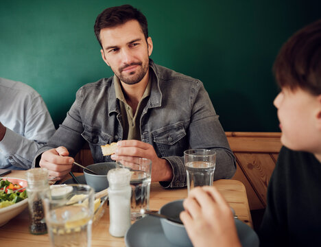 Father And Son Eating Lunch In Kitchen