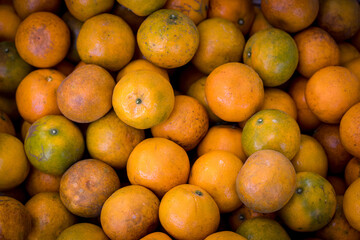 Fresh oranges at a local farmers market. Tangerines as the background. Many fresh and beautiful Oranges with a good taste
