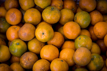 Fresh oranges at a local farmers market. Tangerines as the background. Many fresh and beautiful Oranges with a good taste