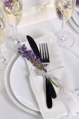 Indulge in a dose of romantic French countryside inspiration with fresh lavender, Lavender Champagne, a folded napkin with cutlery. Detail of the wedding dinner. Wedding theme ideas.