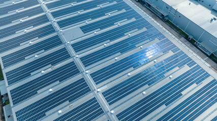 Obraz premium Top view Solar Cell on Warehouse Factory. Solar photo voltaic panels system power or Solar Cell on industrial building roof for producing green ecological electricity. Production of renewable energy.