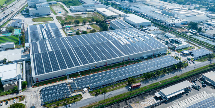 Top view Solar Cell on Warehouse Factory. Solar photo voltaic panels system power or Solar Cell on industrial building roof for producing green ecological electricity. Production of renewable energy.