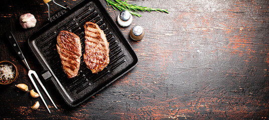 Aromatic grilled steak in a frying pan. 