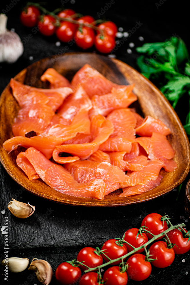 Poster Salted salmon on a wooden plate with greens. 