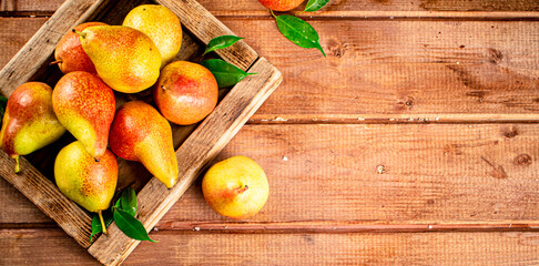 Fresh pears on a tray with leaves. 