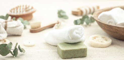 Spa composition with soap, brushes and towels on a blurred background.