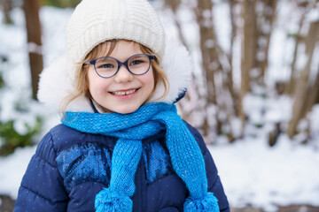 Cute little preschool girl with glasses . Adorable healthy happy child playing and having fun with...