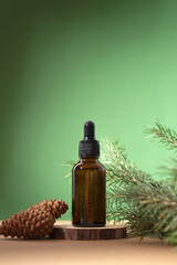 Cosmetic bottle between fir branches and pine cones. Skin care cosmetic. Hyaluronic acid oil, serum with collagen and peptides. Natural cosmetics.