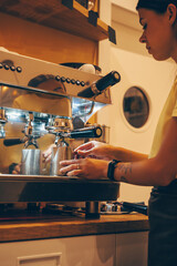 Professional coffee brewing in coffee shop. Barista make coffee cup from coffee machine in warm cozy atmosphere in small cafe.