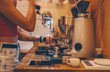 Professional coffee brewing in coffee shop. Barista make coffee cup from coffee machine in warm cozy atmosphere in small cafe.