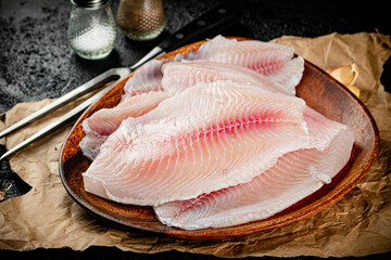 Fresh fish fillet on a wooden plate. 