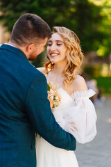 Obraz premium a bride in a delicate dress with a bouquet with the groom in the park