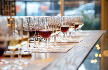 Wine glasses on wooden table filled with wine ready for wine tasting event 