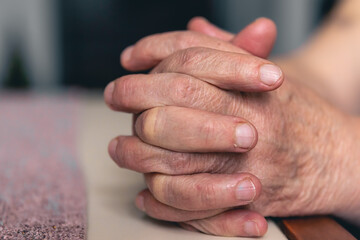 Hands of an old woman folded for prayer.