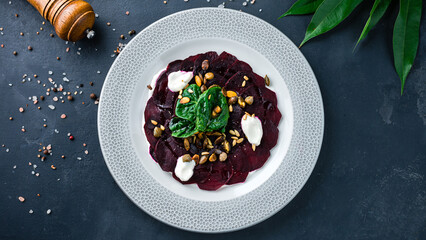 Appetizer of beetroot, pumpkin and sunflower seeds, capers, sour cream and basil.