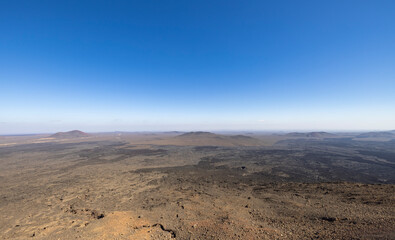 Fototapeta na wymiar Views across the black lava volcano field of Jabal Qidr in the Harrat Khaybar region, north west Saudi Arabia