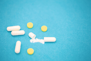 Pills on a blue background, close-up, medicine concept.