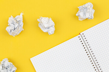 Empty notebook and crumpled paper balls, flat lay.